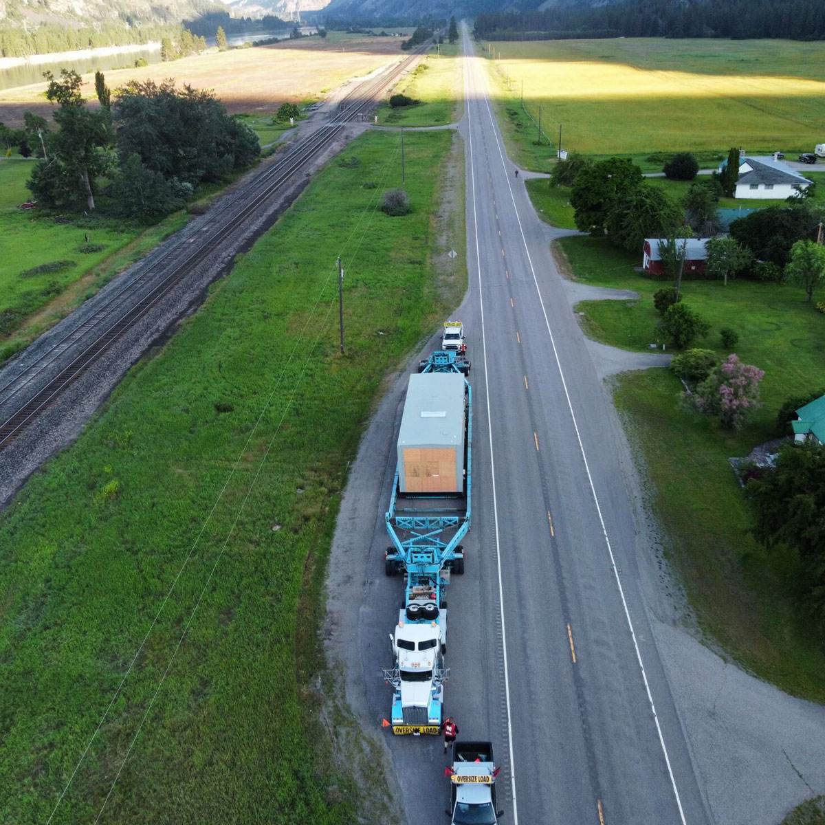 Oversize modular load transported by Triton Transport along a rural highway.